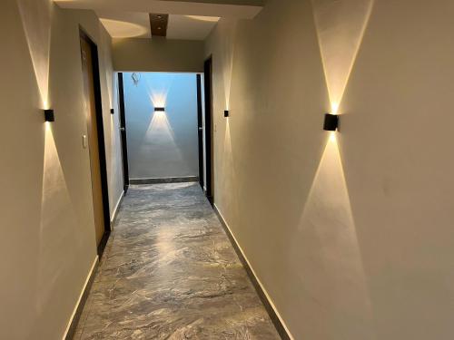 a hallway with two lights on the wall at Hotel Savariya Palace in Ahmedabad