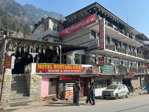 a hotel building with people standing in front of it at OYO Hotel Rohtang View in Manāli