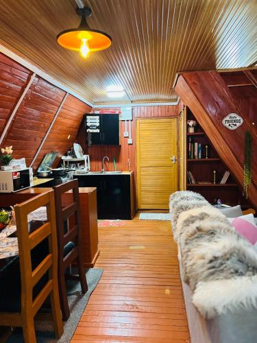 a living room with a couch and a kitchen at Aquawood Cabins in Kianyaga