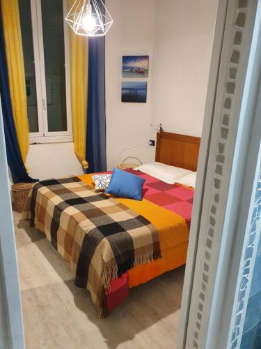 Appartamento a 100 metri dal mare في فرامورا: غرفة نوم مع سرير وبطانية ملونة