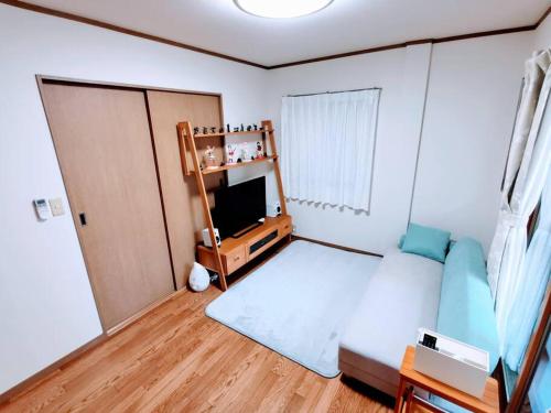 a small bedroom with a bed and a television at Oasis Aoto in Tokyo