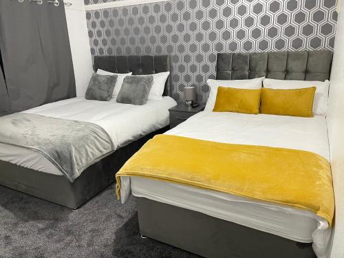 Duas camas sentadas uma ao lado da outra num quarto em Hometel Hidden Gem Large Comfy Home Can Sleep 14 em Braunstone