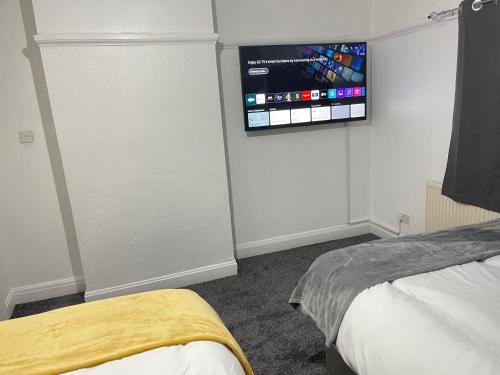 a bedroom with a tv on the wall and a bed at Easystays The Hidden Gem Large Basic Home Can Sleep 15 in Braunstone