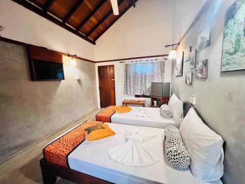 two beds in a room with a room with two at Yala Leopard Lodge in Yala