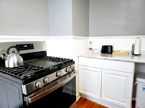 a kitchen with a stove with a tea kettle on it at Lovely! near Cleve Clinic/UH/CWRU/Dwntwn w/porch in Cleveland