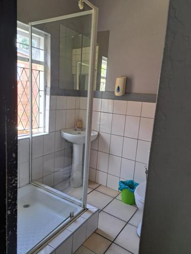 a bathroom with a shower and a sink at PMB Backpackers Lodge in Pietermaritzburg