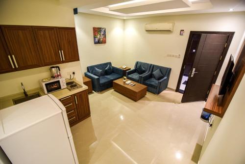 a living room with two blue chairs and a table at هذه ليلتي فرع الحمراء- This Lailaty Al Hamra Branch in Riyadh