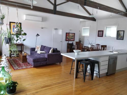 a kitchen and living room with a couch and a table at Pips on Mitchell - Beautiful Historic Apartment in Bendigo