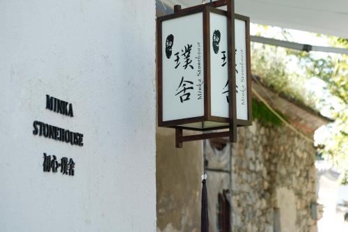 une lanterne suspendue sur le côté d'un bâtiment dans l'établissement Minka Stonehouse 初心·璞舍, à Dali