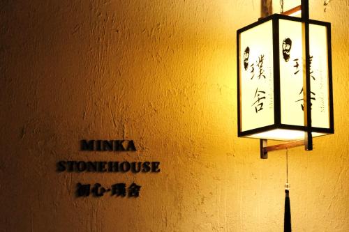 une lumière suspendue à un mur avec un panneau. dans l'établissement Minka Stonehouse 初心·璞舍, à Dali