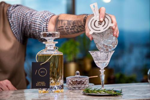 a man pouring a drink into a martini glass at Sheraton Grand Tbilisi Metechi Palace in Tbilisi City