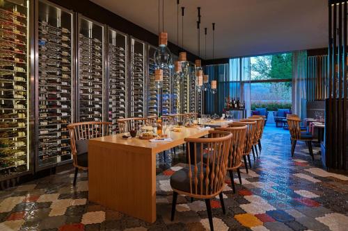 a dining room with a long table with chairs and wine bottles at Sheraton Grand Tbilisi Metechi Palace in Tbilisi City