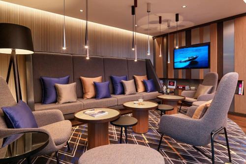 a waiting room with a couch and chairs and a tv at Sheraton Grand Tbilisi Metechi Palace in Tbilisi City