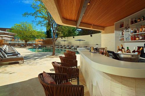 a restaurant with chairs and a bar with a pool at Sheraton Grand Tbilisi Metechi Palace in Tbilisi City