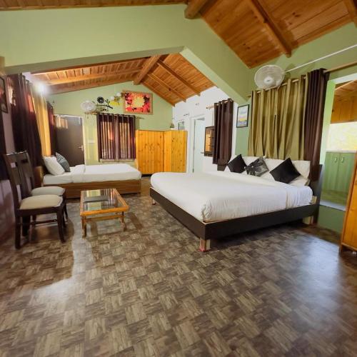 a bedroom with two beds and a couch and a table at THE NINE RESORT in Bhīm Tāl