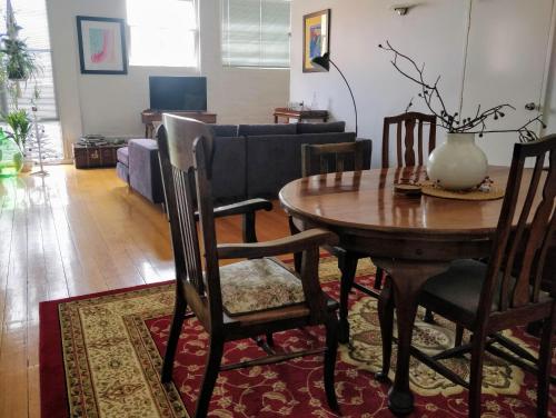 a living room with a table and chairs and a couch at Pips on Mitchell - Beautiful Historic Apartment in Bendigo