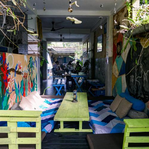 a table and chairs in a room with graffiti at Cycling Backpacker Hostel in Unawatuna
