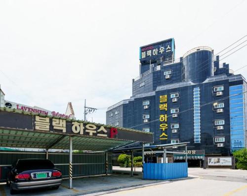 a car parked in a parking lot in front of a building at Buantreehotel Blackhouse in Buan