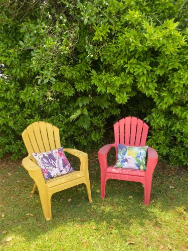two chairs with pillows sitting in the grass at Mission Retreat in Kerikeri