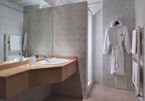 un bagno con un accappatoio bianco appeso al muro di Hotel Terme Bologna ad Abano Terme