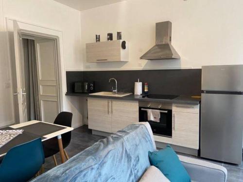 uma cozinha com um sofá, um frigorífico e uma mesa em Le Navy Blue em Vesoul