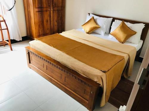 um quarto com uma cama grande e almofadas amarelas em Senik villa em Kalutara