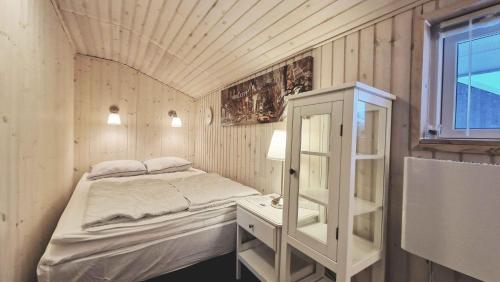 Habitación pequeña con cama y ventana en Nice Summer House , Spa, Sauna, Wood Stove, Tv, en Sønderby