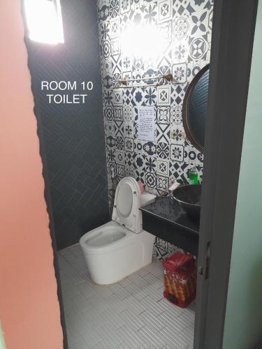 a bathroom with a toilet and a black and white tiles at Nhà Yên 1 Bed 2 Beds Hotel Homestay Hostel Cần Thơ in Can Tho
