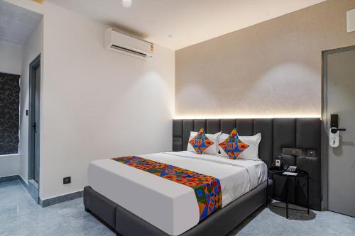 a bedroom with a large white bed with colorful pillows at FabHotel Prime Cloud 5 Studios in Madhapur