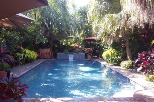a large swimming pool in a yard with trees at Tropical OASIS Getaway with a Private Pool & Spa in New Orleans