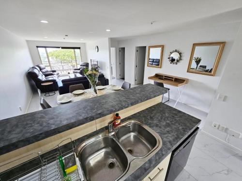 a kitchen with a sink and a living room at Spacious and Luxury, City Fringe Bliss! in Wellington