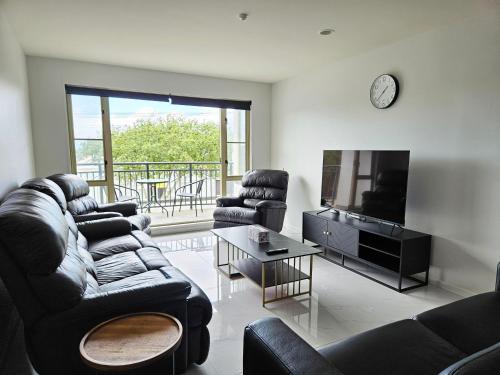 a living room with couches and a television and a table at Spacious and Luxury, City Fringe Bliss! in Wellington