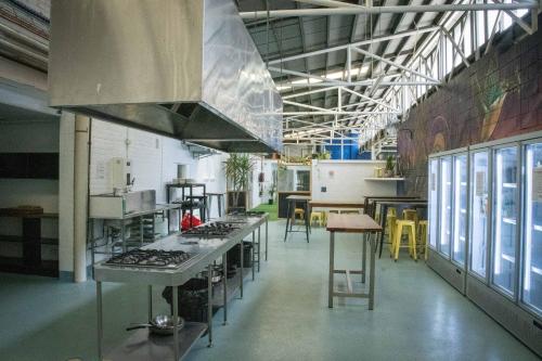 a kitchen with a stove top oven in a room at Habitat Backpackers in Brisbane