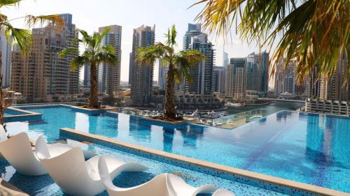 a large swimming pool with palm trees and buildings at Jumeirah Marina Gate Residences in Dubai