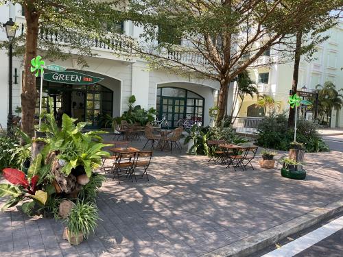 a group of tables and chairs in front of a building at Green Inn Phu Quoc Hotel in Phu Quoc