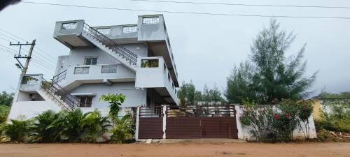 un edificio blanco con una escalera delante en Aadhya guest house, en Tiruvannāmalai