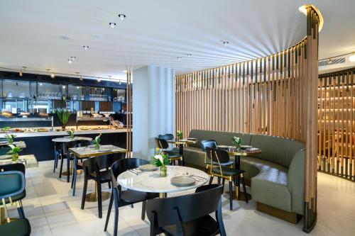 a restaurant with tables and chairs and a bar at Jewel TLV Hotel in Tel Aviv