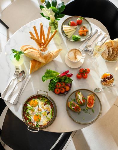 a white table with plates of food on it at Jewel TLV Hotel in Tel Aviv