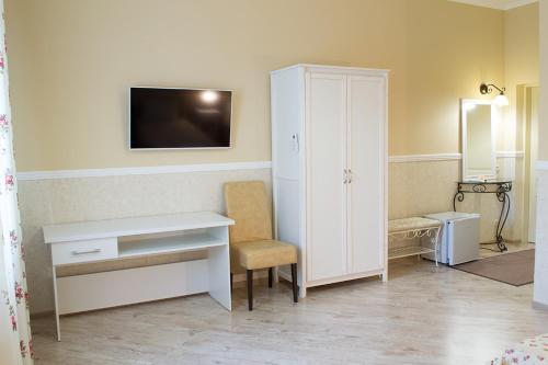 a room with a desk and a cabinet and a tv at Green Hall Hotel in Izmail