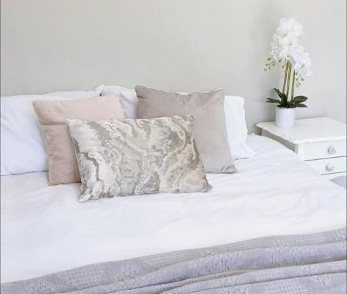 - un lit blanc avec un oreiller dans l'établissement Shades of Blue, à Mossel Bay