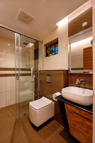 a bathroom with a toilet and a sink and a shower at Casa Bella, Thekkady in Thekkady
