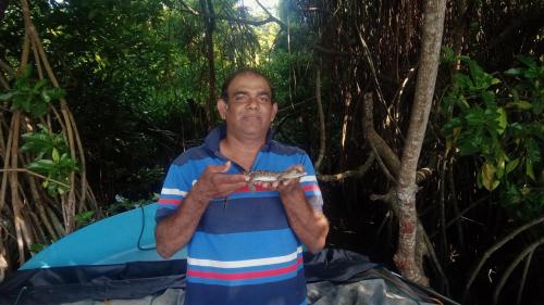 a man holding a fish in his hands at Little Swan Guest house in Bentota