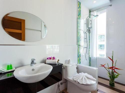 a bathroom with a sink and a toilet and a mirror at The Samui Beach Resort in Koh Samui