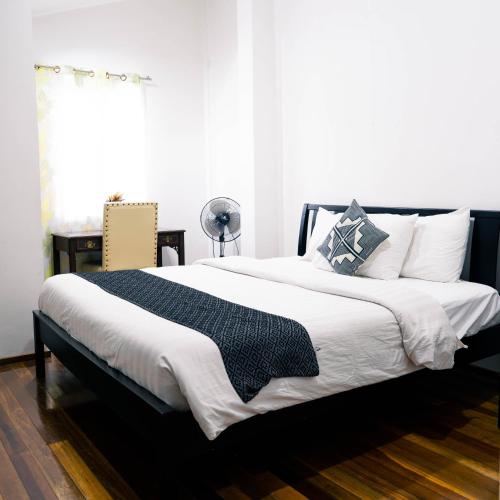a bedroom with a large bed with a black frame at 87 Guesthouse in Baguio