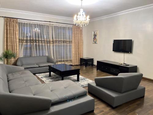 a living room with two couches and a television at Rose house in Dar es Salaam