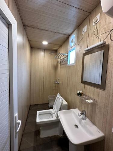 a bathroom with a sink and a toilet and a mirror at Hotel Divine Ayodhya- A Unit of Chinar Services in Ayodhya