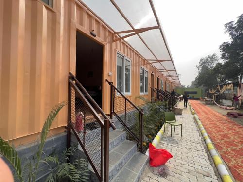 a building with a porch with a red bag on the stairs at Hotel Divine Ayodhya- A Unit of Chinar Services in Ayodhya