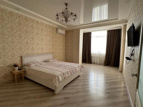 a bedroom with a bed and a chandelier at Lovely house in the city center in Bishkek