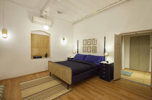 ein Schlafzimmer mit einem Bett mit blauen Kissen in der Unterkunft Souzagad - Villa Maria in Pune