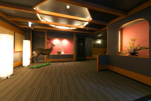 a room with a statue of a deer in the middle at Shikanoyu Hotel in Komono